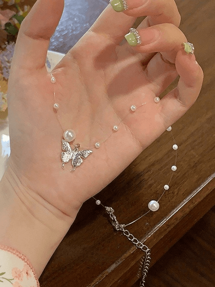 Faux pearl necklace with butterfly charm