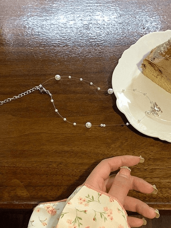 Faux pearl necklace with butterfly charm