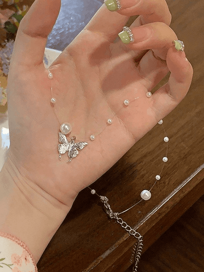 Faux pearl necklace with butterfly charm